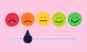 5 smiley faces in a roq changing from red to green going left to right, with a scale from sad to happy. A pointer rests at 'slightly unhappy'